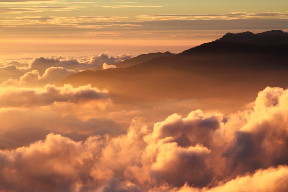 Silhouette Of Mountain With Fluffy Clouds During Sunset