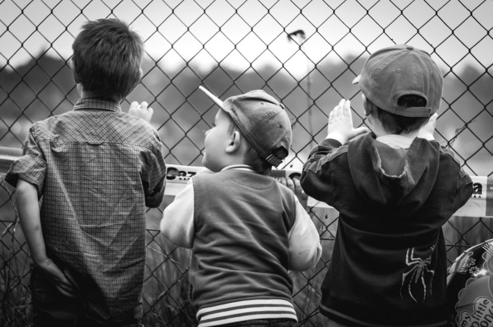 Boys Standing By Wire Fence