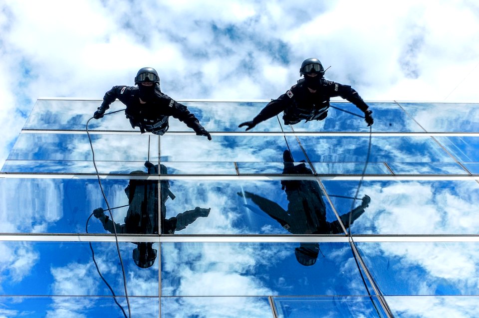 Gendarmes Climbing Down Building