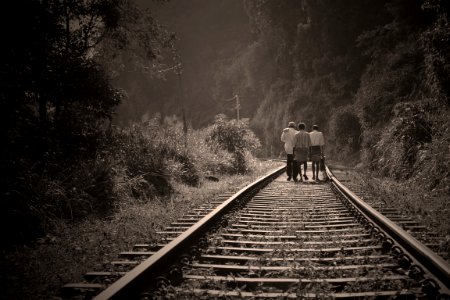 People Walking On Railroad Tracks photo