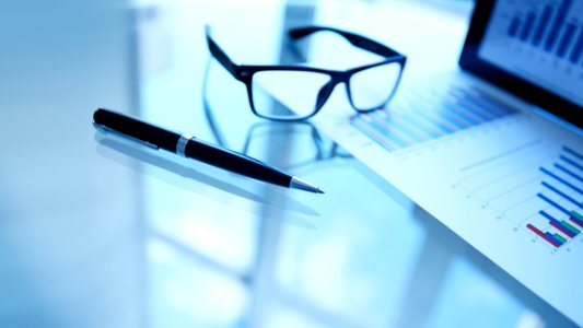 Glasses And Pen Next To Business Data photo
