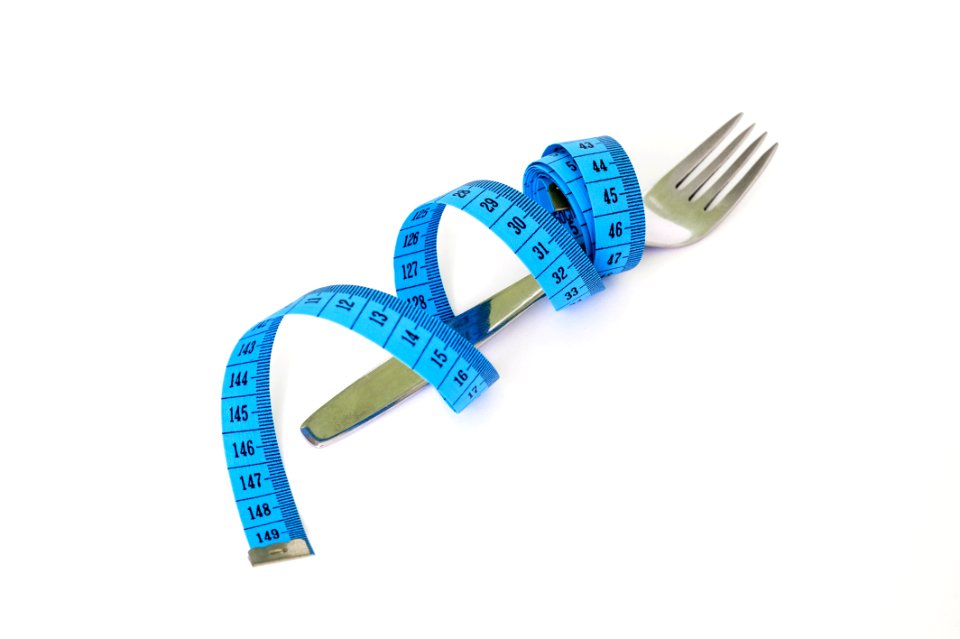 Blue And Black Measuring Tape Wrapped Around A Silver Metal Fork