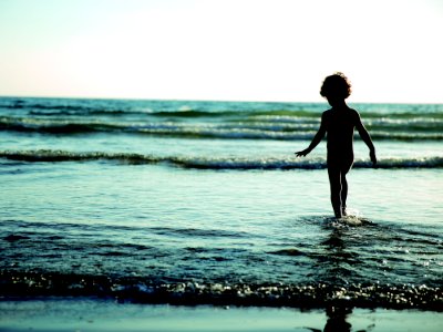 Child Walking On Seashore During Daytime photo