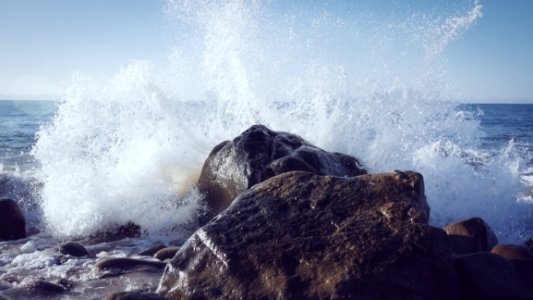 Ocean Wave Splashing Against Rocks photo