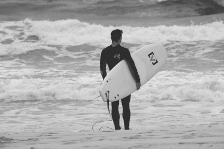 Surfer With Surfboard On Beach