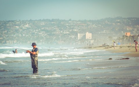 Man Fishing On Ocean Beach photo