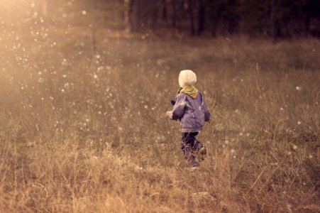 Boy Running Through Raindrops In Field photo