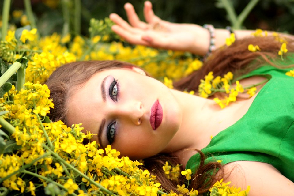 Close-up Portrait Of Young Woman With Yellow Flowers