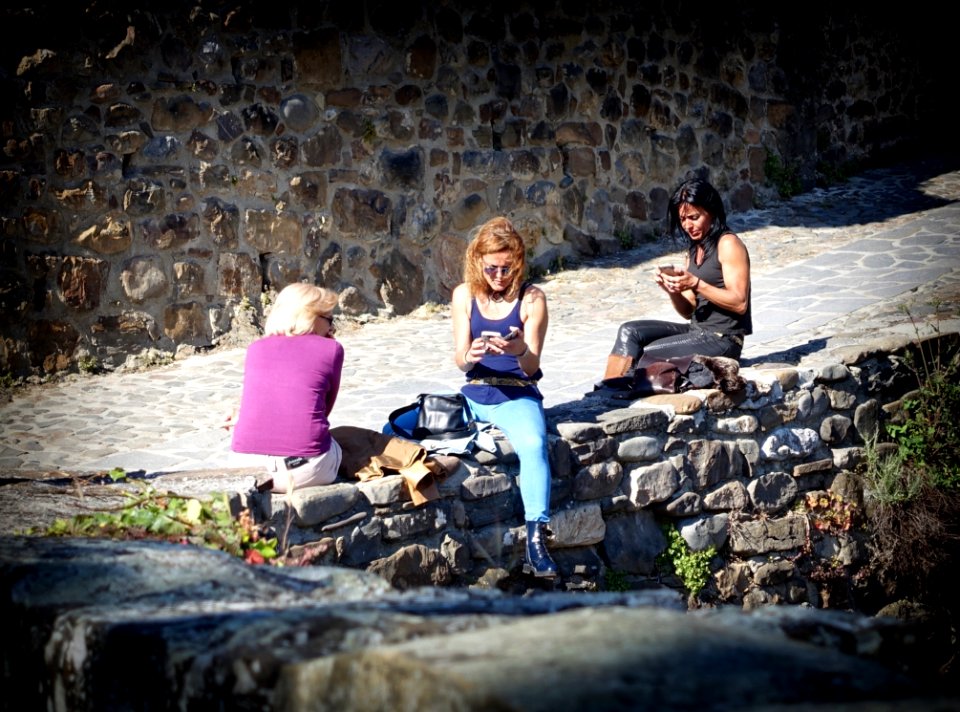 People Sitting On Stone Wall
