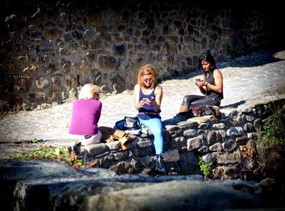 People Sitting On Stone Wall