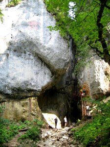 People Exploring Cave In Mountains