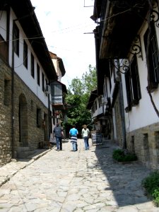 People Walking Down A Cobblestone Alley