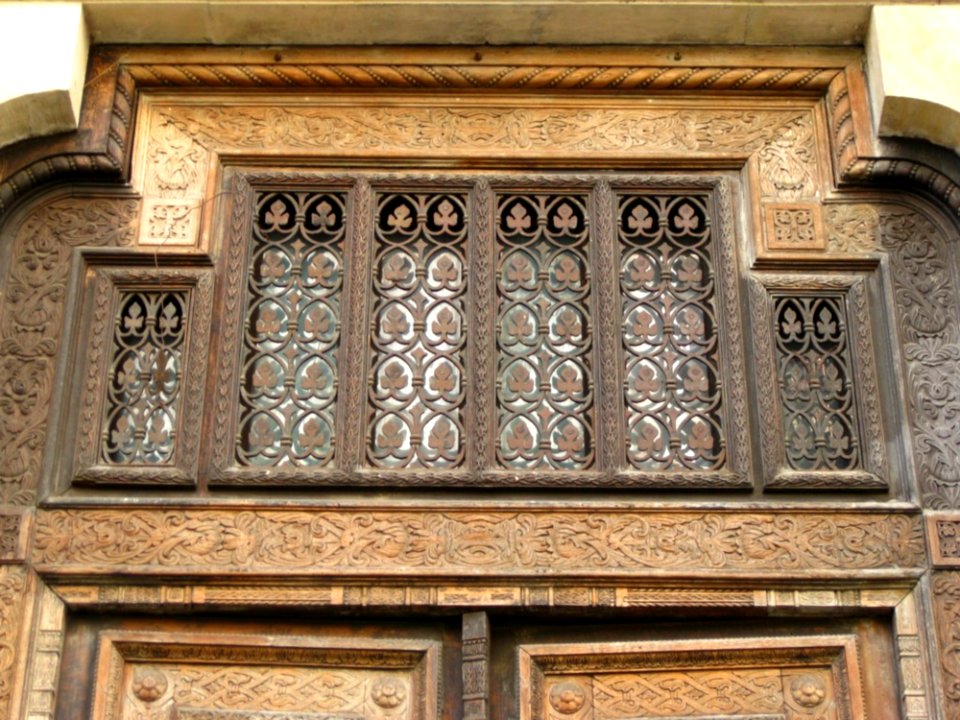 Wrought-iron-ornamentation-above-carved-wooden-door
