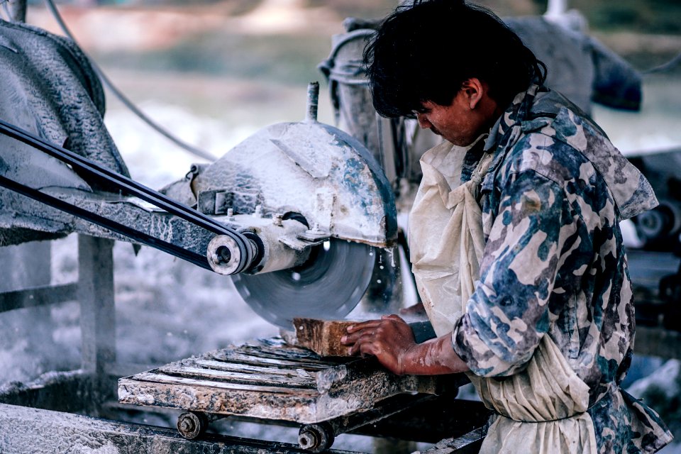 Carpenter In Uniform Cutting Wood
