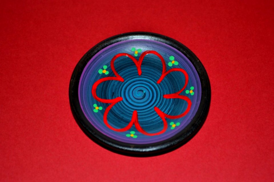 Miniature-ceramic-plate-isolated-on-red