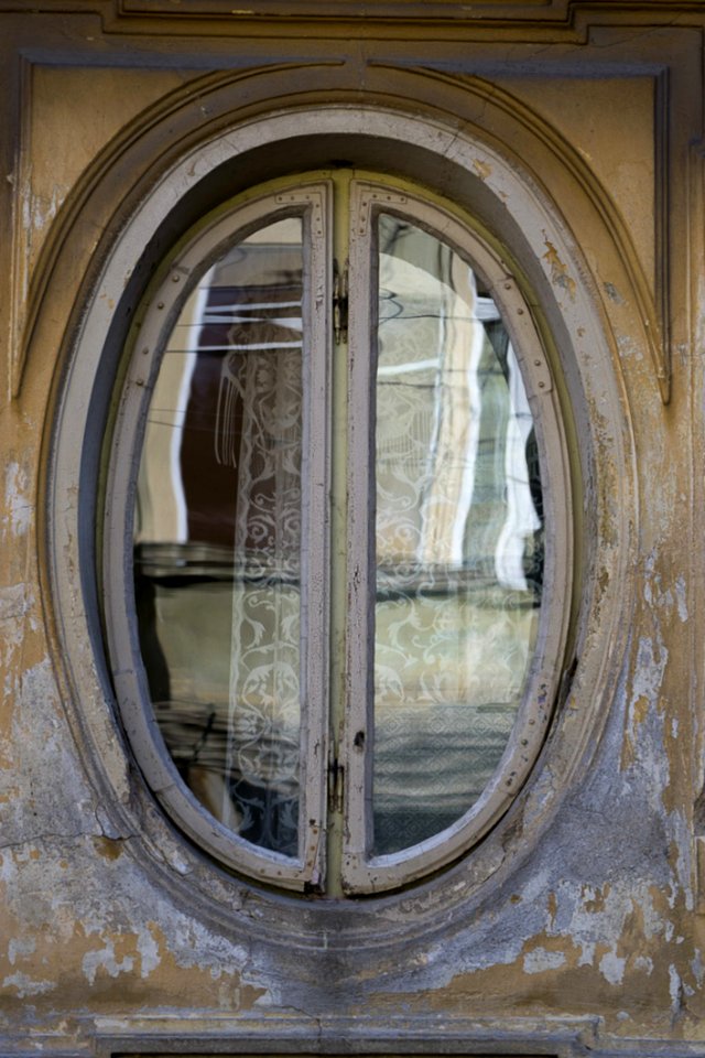 Photo Of An Oval Shaped Window Frame On Old House Facade