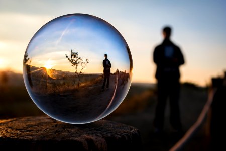 Person Reflected In Ball At Sunset photo