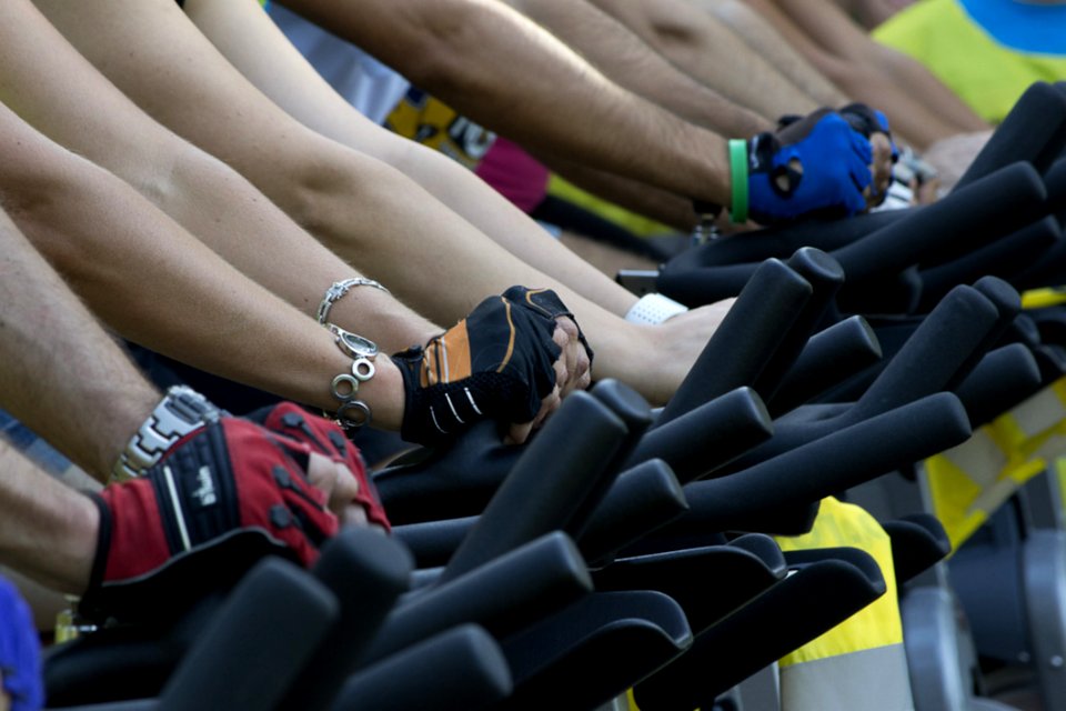 People Lined Up On Exercise Bikes At A Fitness Session