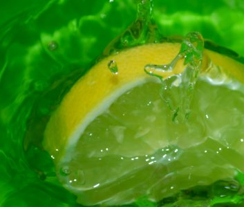 Slice Of Lemon Making Splash In Water Bowl photo