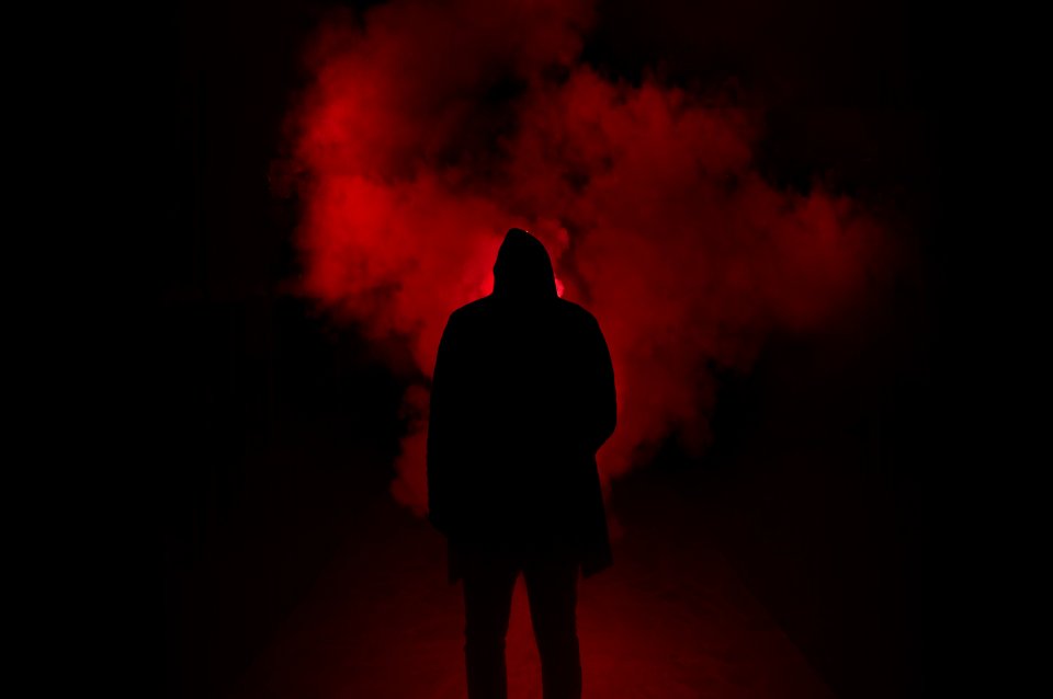 Silhouette Of Man Standing Against Black And Red Background