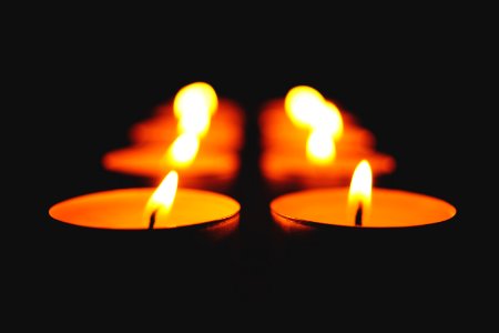 Close-up Of Illuminated Candle Against Black Background photo