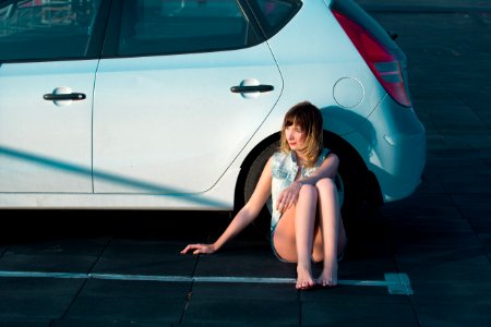 Woman Sitting Beside Car