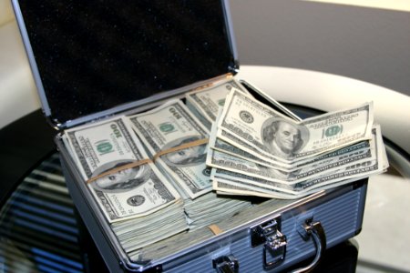Piles Of Us Dollar Bills On Silver And White Suitcase photo