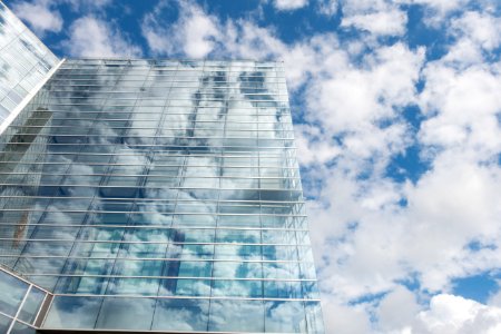 Bottom View Of Clear Glass Building Under Blue Cloudy Sky During Day Time photo