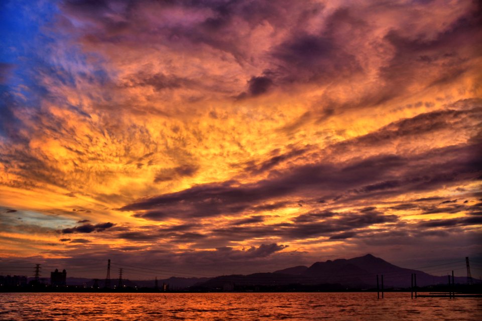 Sea And Silhouette Of Mountain Under Orange Sky During Golden Hour