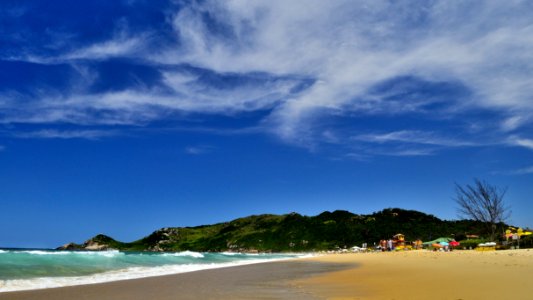 Green Mountain Near Sea Under White Clouds And Blue Sky photo