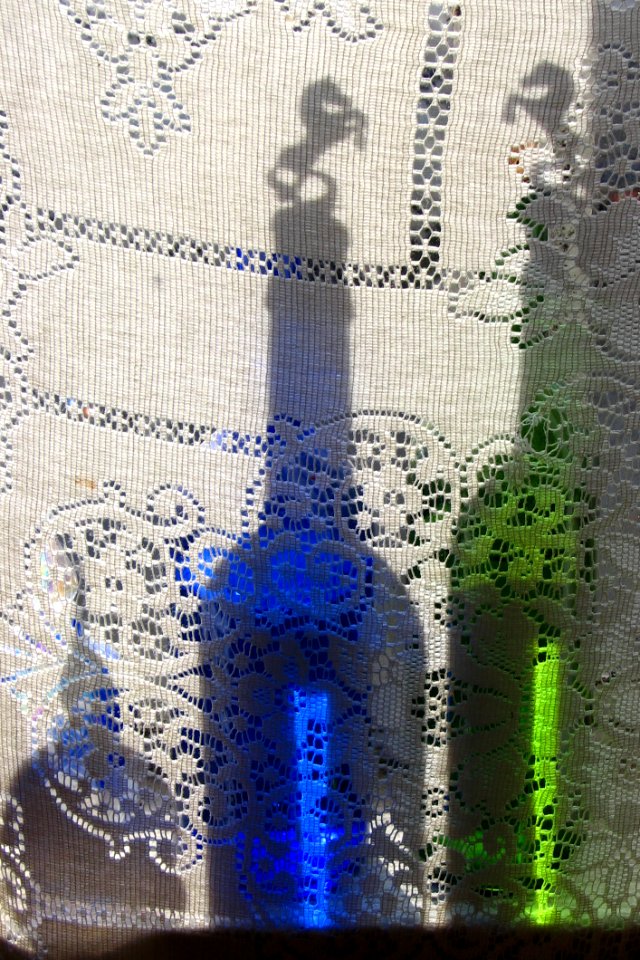 Bottles Behind Lace Curtain