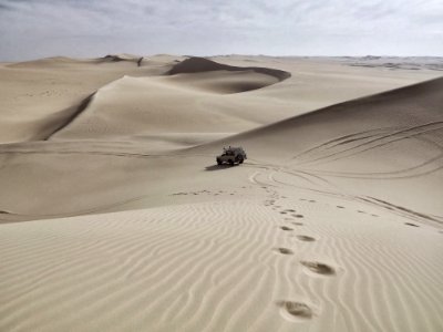 Automobile And Tire Tracks In A White Desert With Sand Dunes