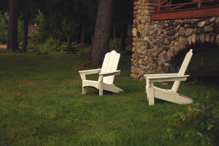 Two White Wooden Lawn Chairs In Grass By Home photo
