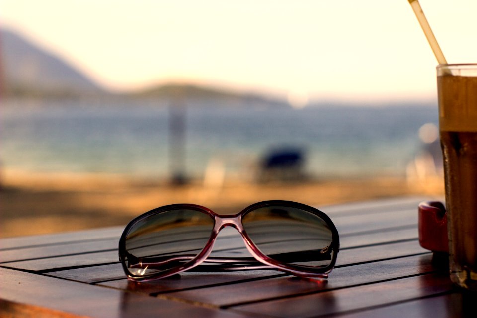 Pink Plastic Framed Wayfarer Sunglasses On Brown Table Top photo