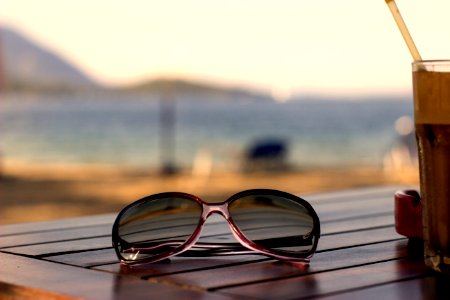 Pink Plastic Framed Wayfarer Sunglasses On Brown Table Top photo