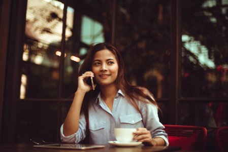 Portrait Of Young Woman Using Mobile Phone In Cafe photo