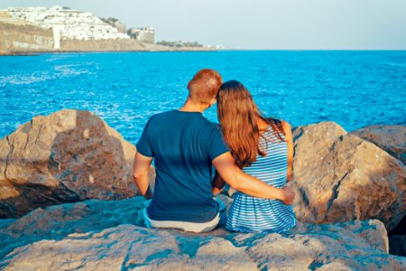 Rear View Of Couple Sitting On Beach photo