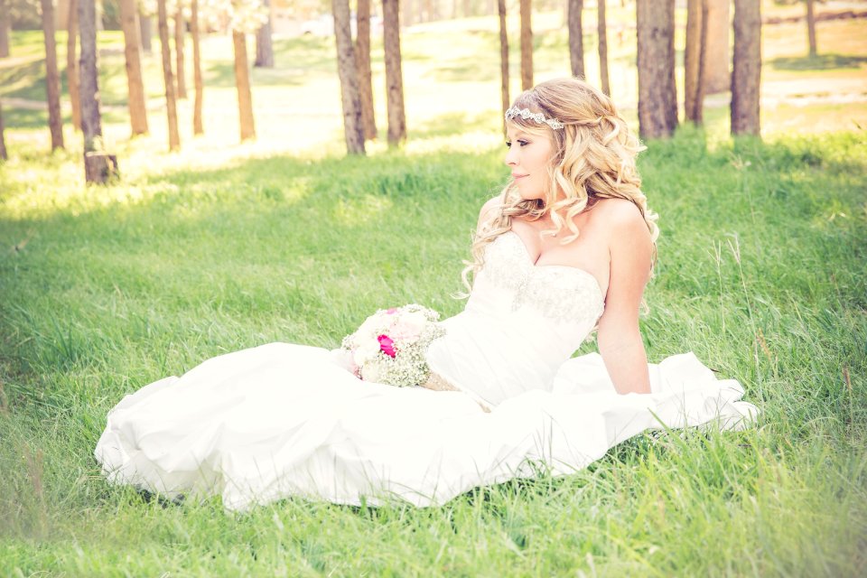 Bride Sitting In Sunny Field