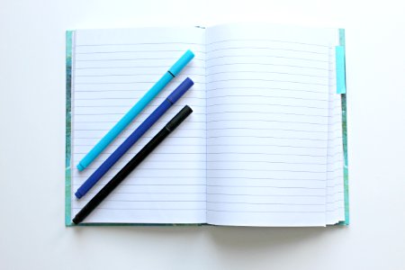 Lined Notebook Open With Three Pens photo