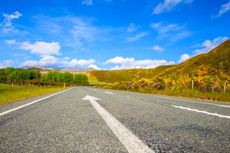 Road Passing Through Landscape Against Blue Sky photo