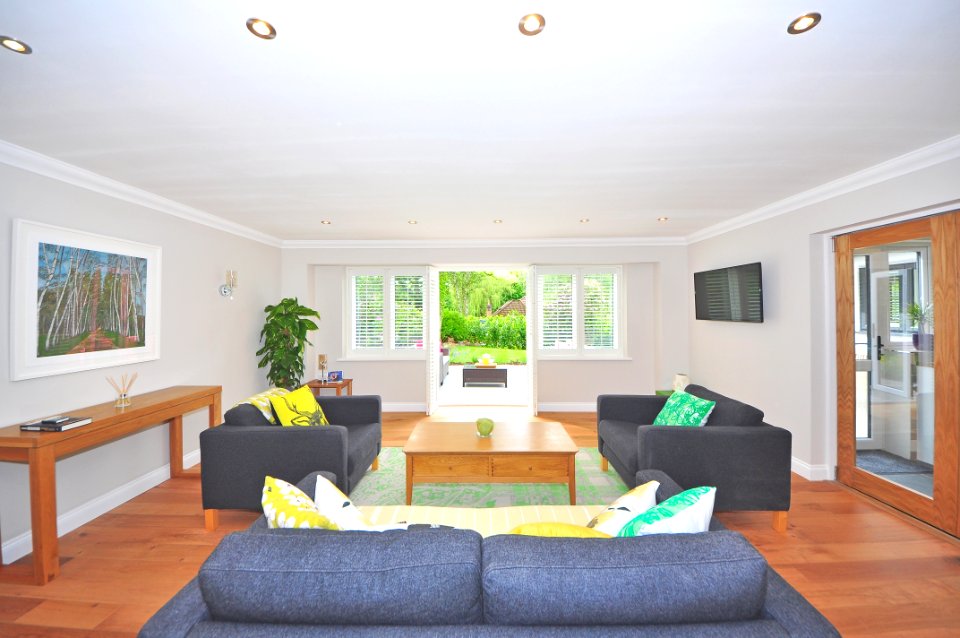 Brown Wooden Coffee Table Near Black Sofa Near The Window