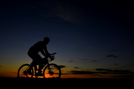 Man Riding Bicycle During Nightfall photo
