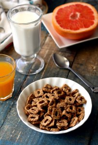 Chocolate Cereal On White Bowl Near Glass Of Milk photo