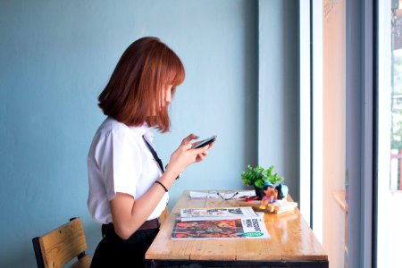 Girl Using Mobile Phone At Home photo