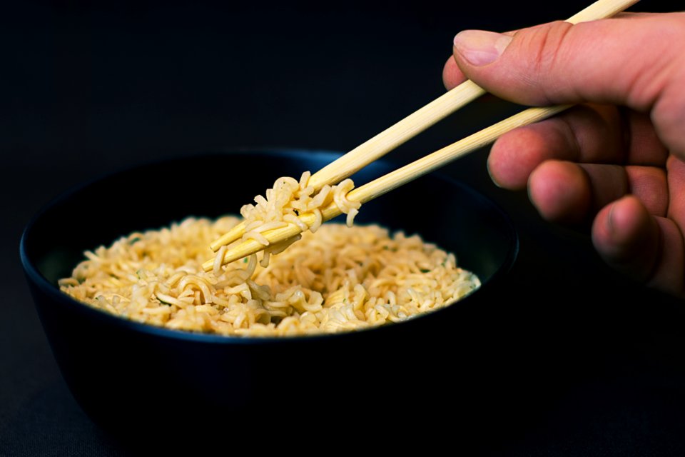 Person Holding A Chopsticks And Picking A Noodles In Black Bowl photo