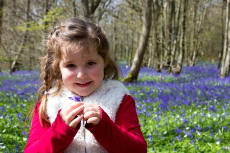 Girl In Red And Beige Jacket Holding Purple Petaled Flower photo