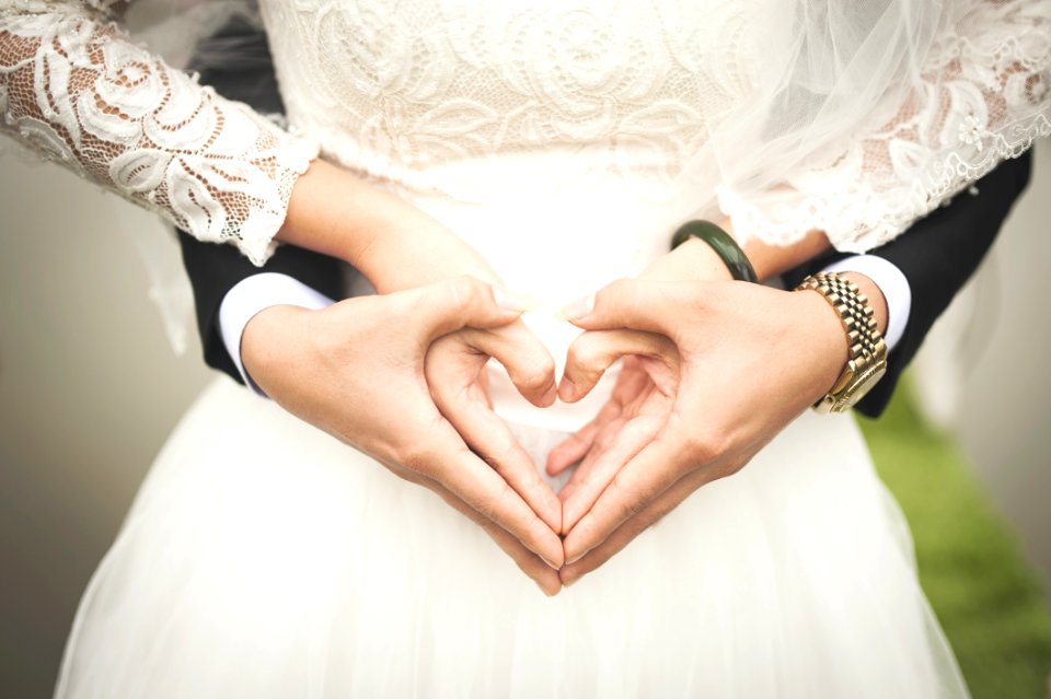 Midsection Of Woman Making Heart Shape With Hands