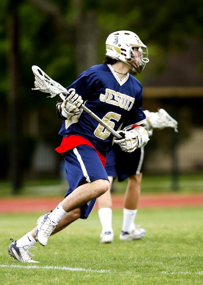 Man In Blue And White Jersey Playing Lacrosse