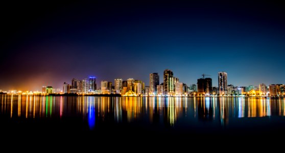 City At Night Reflected On Ocean photo