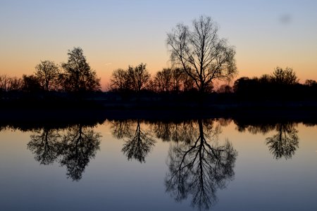 Reflection Of Silhouette Trees In Lake Against Sky At Sunset